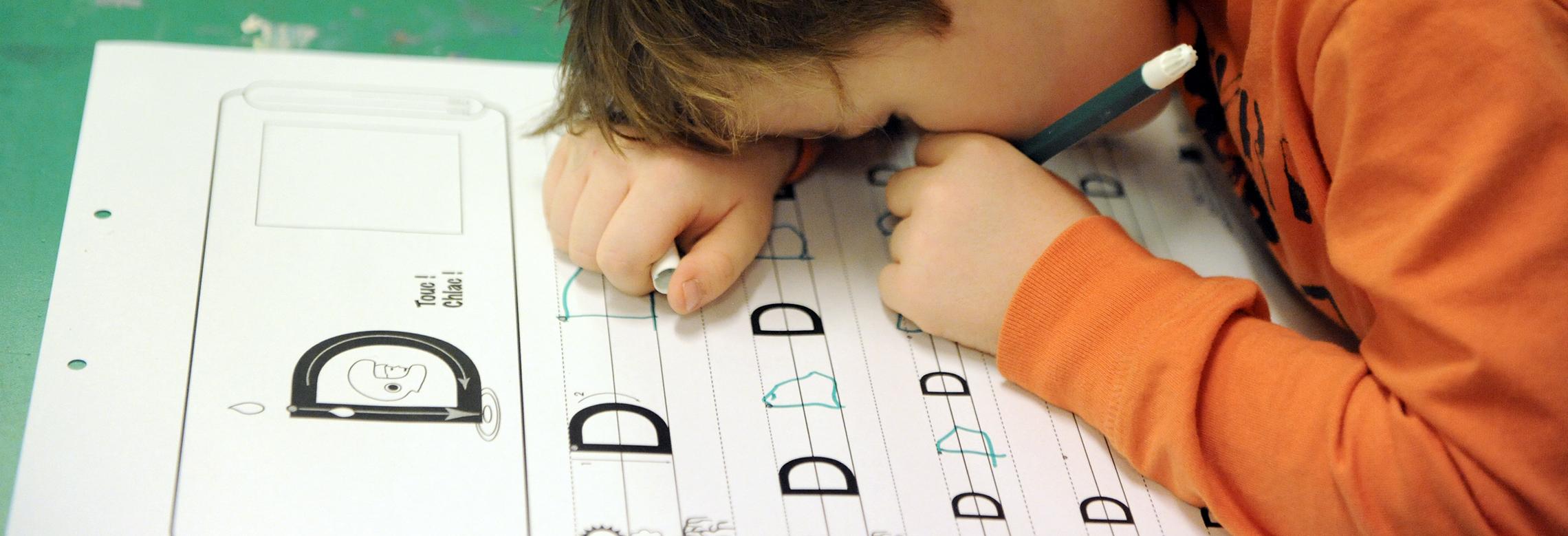 Image d'un enfant écrivant de très près